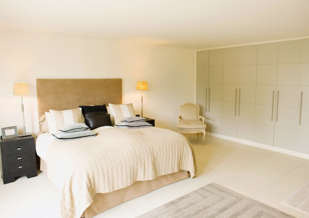 a bedroom with a side table and a chair a bedroom with a side table and a chair